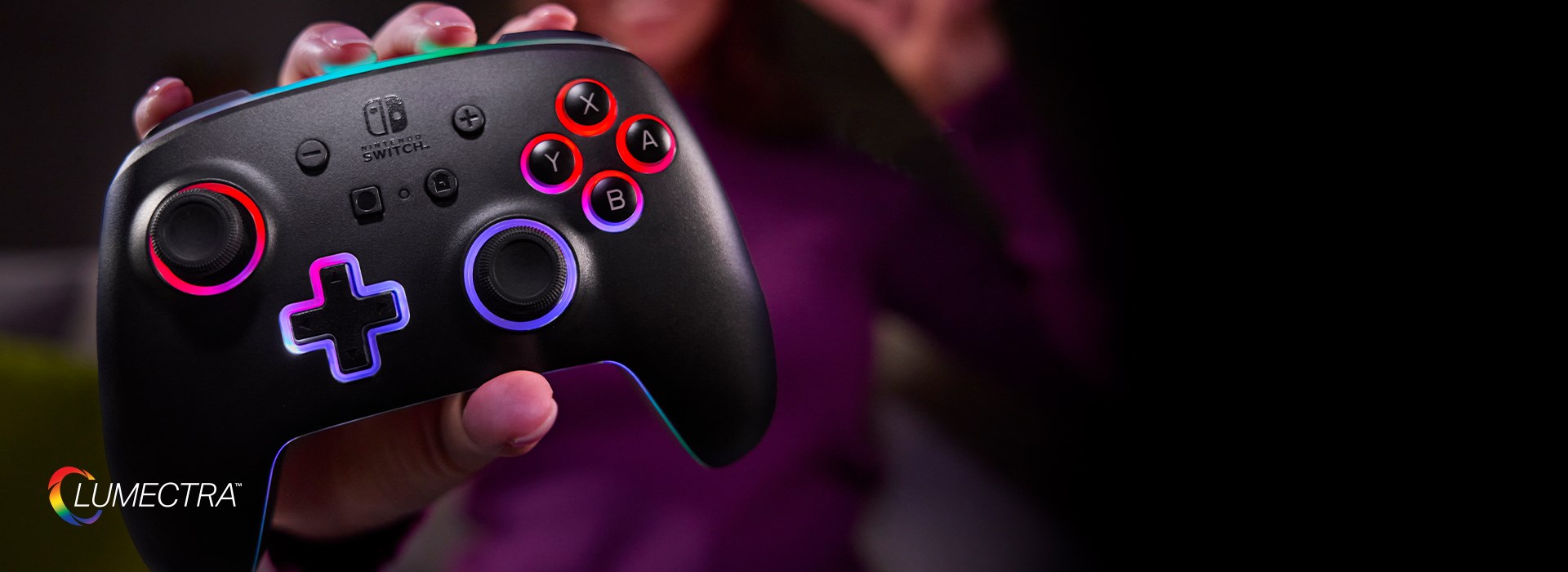 A hand gripping a glowing Lumectra controller holding it up to the camera